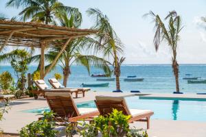 a resort with a pool and chairs and the ocean at Ocean Boutique Hotel - Adults only in Pingwe