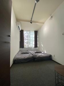 うるま市にあるゲストハウスUYokinawaの窓のある部屋にベッドがある寝室