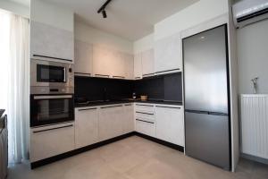 a kitchen with white cabinets and stainless steel appliances at N & M Suites in Igoumenitsa