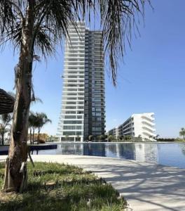 a tall building next to a body of water at Grand Sapphire One Bedroom Luxury Residences By MyGuest Cyprus in Iskele