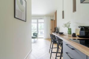 a kitchen with a counter and stools in a room at Verde Kato Apartment Francuska - FREE PARKING - Self check-in in Katowice