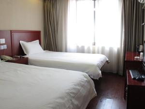 Een bed of bedden in een kamer bij GreenTree Inn Guangxi Nanning Baisha Avenue Provence Business Hotel