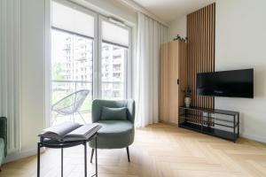 a living room with a chair and a table and a tv at Verde Kato Apartment Francuska - FREE PARKING - Self check-in in Katowice
