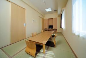 um quarto vazio com uma mesa de madeira e cadeiras em Chisun Inn Kagoshima Taniyama em Kagoshima