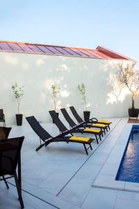 une rangée de chaises assises à côté d'une piscine dans l'établissement Villa Mara by IstriaLux, à Svetvinčenat