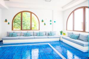 a living room with a couch and a pool at Pietrablu Resort & Spa - CDSHotels in Polignano a Mare