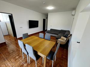 a dining room with a table and chairs and a couch at Beautiful House Delta Ebro in Camarles