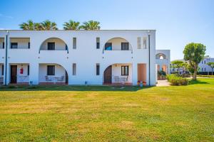 a large white building with a grass yard at Pietrablu Resort & Spa - CDSHotels in Polignano a Mare