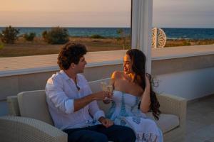 a man and woman sitting on a couch with a glass of wine at Pietrablu Resort & Spa - CDSHotels in Polignano a Mare