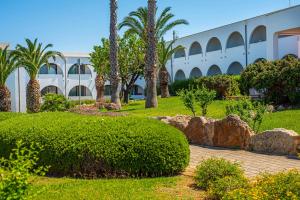 a park with palm trees and a building at Pietrablu Resort & Spa - CDSHotels in Polignano a Mare