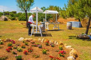 a man standing at a table in a garden with flowers at Pietrablu Resort & Spa - CDSHotels in Polignano a Mare