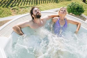 a man and a woman sitting in a hot tub at Pietrablu Resort & Spa - CDSHotels in Polignano a Mare