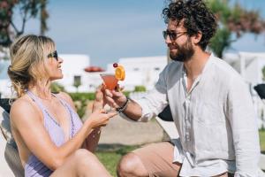 a man is giving a woman a drink at Pietrablu Resort & Spa - CDSHotels in Polignano a Mare