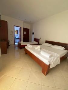 two beds in a large room with at Hotel Afrodite in Dhërmi