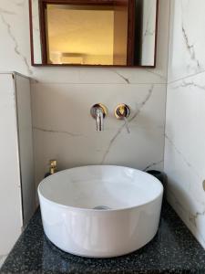 a bathroom with a white sink and a mirror at Hotel Afrodite in Dhërmi