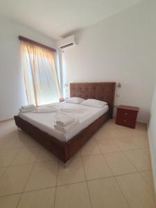 a large bed in a room with a window at Hotel Afrodite in Dhërmi
