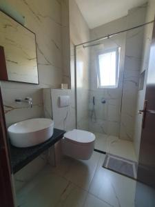 a bathroom with a sink and a toilet and a shower at Hotel Afrodite in Dhërmi