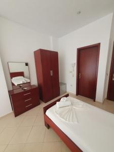 a bedroom with a large bed and a mirror at Hotel Afrodite in Dhërmi