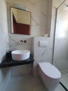 a bathroom with a sink and a toilet at Hotel Afrodite in Dhërmi