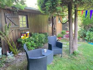 a yard with chairs and a table and a tree at Chambre à la venelle in Caen