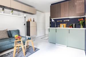 Una sala de estar con un sofá azul y una mesa. en MOVEEN! Apartamenty Wrocław Nowoczesne studia z parkingiem! 10 min od centrum, en Wroclaw 166 fotos más