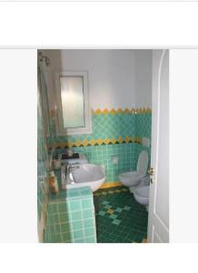 a bathroom with two toilets and a sink and a tub and a sink at BELLA VISTA Apartment Castelsardo in Castelsardo
