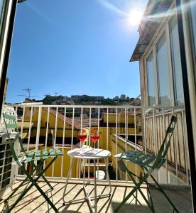 a balcony with two chairs and a table with a glass of wine at Montesanto Charm Centro Storico in Naples