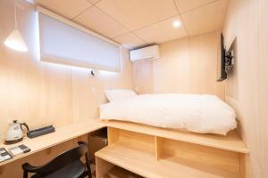a small bedroom with a bed on a desk at raw 白馬唯一屋上露天を独り占めできるデザインコンテナホテル in Hakuba