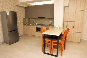 a kitchen with a wooden table and a refrigerator at Silent Apartment 1 in Yerevan