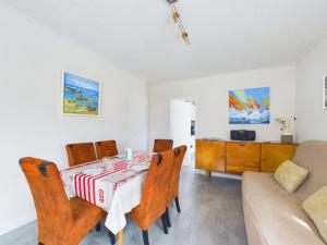 ein Esszimmer mit Tisch und Stühlen und einer Couch in der Unterkunft À 300m de la plage, maison pour 5 in Brétignolles-sur-Mer