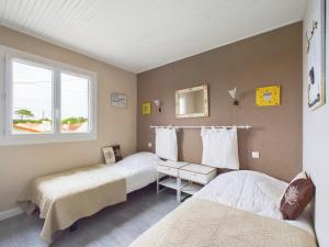 ein Schlafzimmer mit zwei Betten und einem Fenster in der Unterkunft À 300m de la plage, maison pour 5 in Brétignolles-sur-Mer