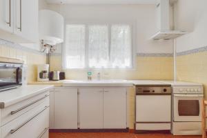 een keuken met witte kasten en een raam bij À moins de 2km de la plage, maison pour 6 in Andernos-les-Bains +14 foto's