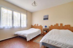 een slaapkamer met 2 aparte bedden en een raam bij À moins de 2km de la plage, maison pour 6 in Andernos-les-Bains