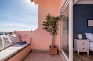 a balcony with a couch and a potted plant at Luxury Sea View in Cascais +54 photos
