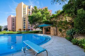 a swimming pool with a blue bench next to a building at Luxury Sea View in Cascais