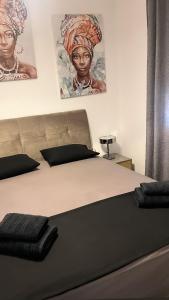 a bed in a bedroom with two pictures on the wall at Sea View Residence by MD in Alexandroupoli