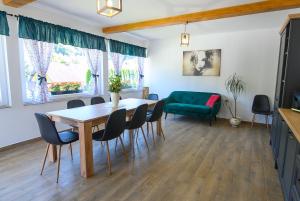 a living room with a table and chairs and a couch at Cozy Rooms in Praid