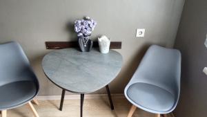 a table with a vase of flowers and two chairs at Гоголя 68 in Karagandy