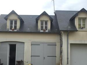 ein Haus mit zwei Garagentüren und zwei Fenstern in der Unterkunft Appartement à 2 pas de la plage in Cabourg