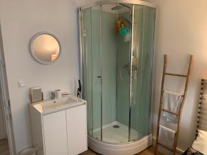 ein Badezimmer mit Glasdusche und Waschbecken in der Unterkunft Appartement à 2 pas de la plage in Cabourg