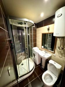 een badkamer met een douche, een toilet en een wastafel bij Гоголя 68 in Karagandy