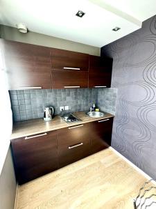 een keuken met houten kasten en een spoelbak bij Гоголя 68 in Karagandy