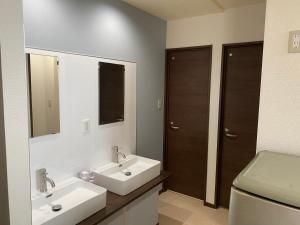 うるま市にあるゲストハウスUYokinawaのバスルーム(洗面台2台、トイレ付)