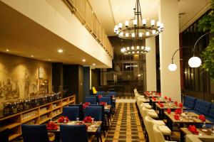 a dining room with tables and blue chairs at Patra Malioboro Hotel in Yogyakarta
