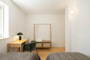 a bedroom with a desk and a bed and a mirror at Azul Downtown Apartments in Coimbra +8 photos