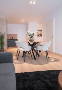 アシャッフェンブルクにあるSCHÖNTALHAUS City Apartmentsのダイニングルーム(テーブル、白い椅子2脚付)