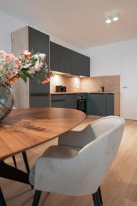 アシャッフェンブルクにあるSCHÖNTALHAUS City Apartmentsの木製テーブルと花瓶付きのキッチン