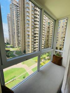a large window with views of tall buildings at Sophisticated 2bhk in Bhartiya city near manyata tech park in Yelahanka