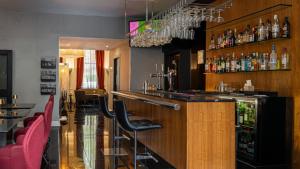 a bar in a restaurant with red chairs at The Queens Gate Hotel in London
