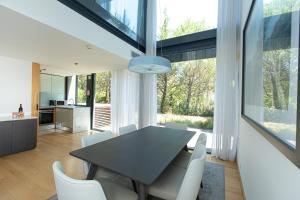 a dining room with a black table and white chairs at VILLA FARHAT in Troia